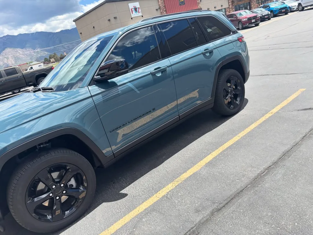Teal Jeep Grand Cherokee tinted at the West Haven shop, Wasatch range behind